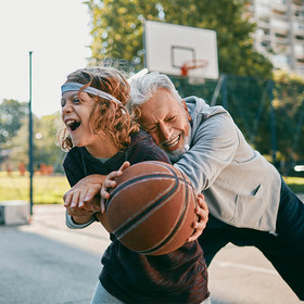 Junge spielt mit Opa Basketball